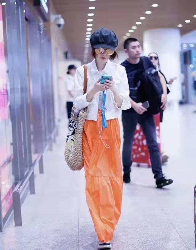 49岁鲁豫少女风现身机场，穿亮橘长裙瘦出新高度，这身材有60斤吗