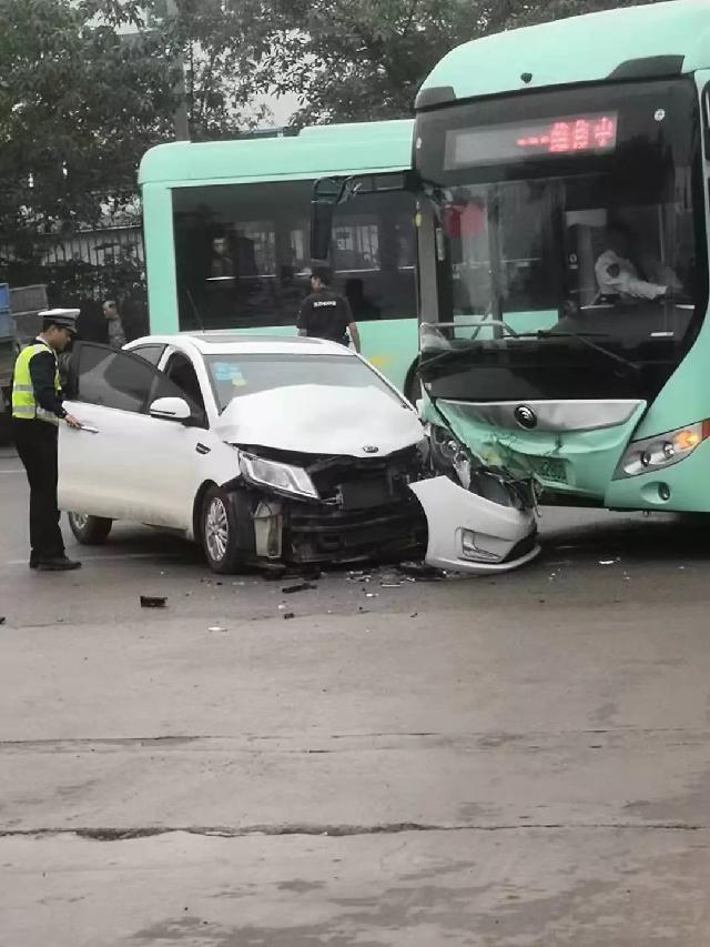 公交站门口一辆白色小车与公交车相撞
